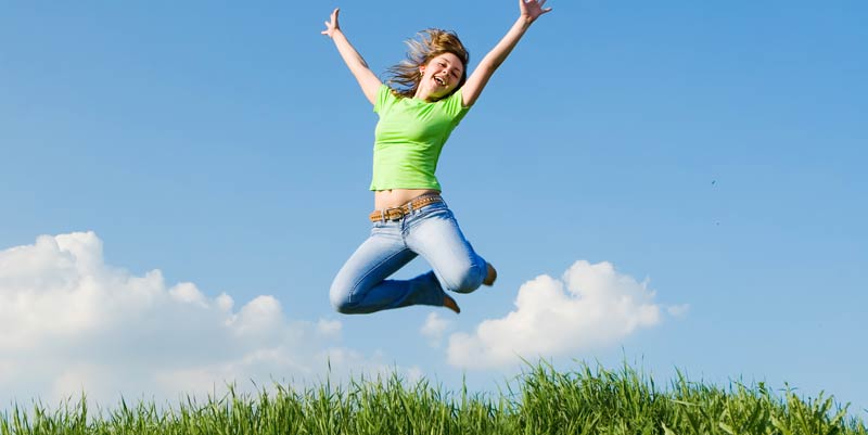 Fille heureuse qui saute en l'air dans la nature