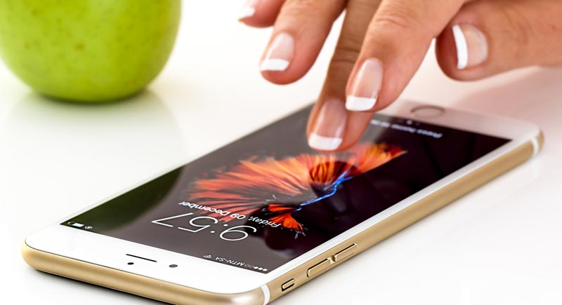 Photographie d'un smartphone et d'une pomme pour illustrer des applications en lien avec l'alimentation