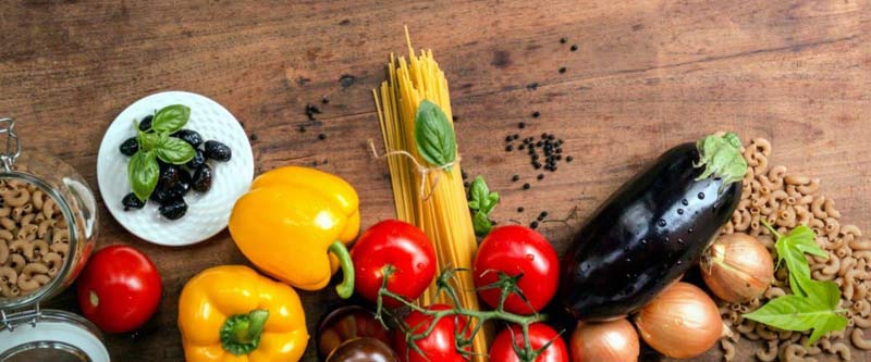 Photos de légumes et de pâtes sur une table en bois : le régime végétarien est positif pur le plus grand bonheur des végétariens