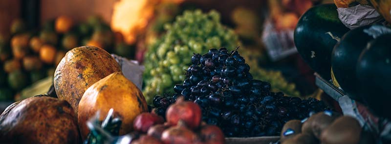 Aliments bio : assortiment de fruits sur l'étal d'un marchand en gros plan.