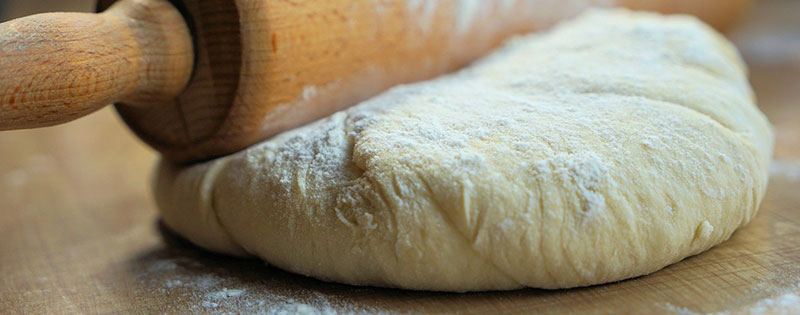 Rouleau à pâtisserie sur une pâte à pain pétrie