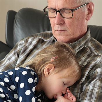 Sommeil et surpoids : un grand-père assoupi avec sa petite-fille